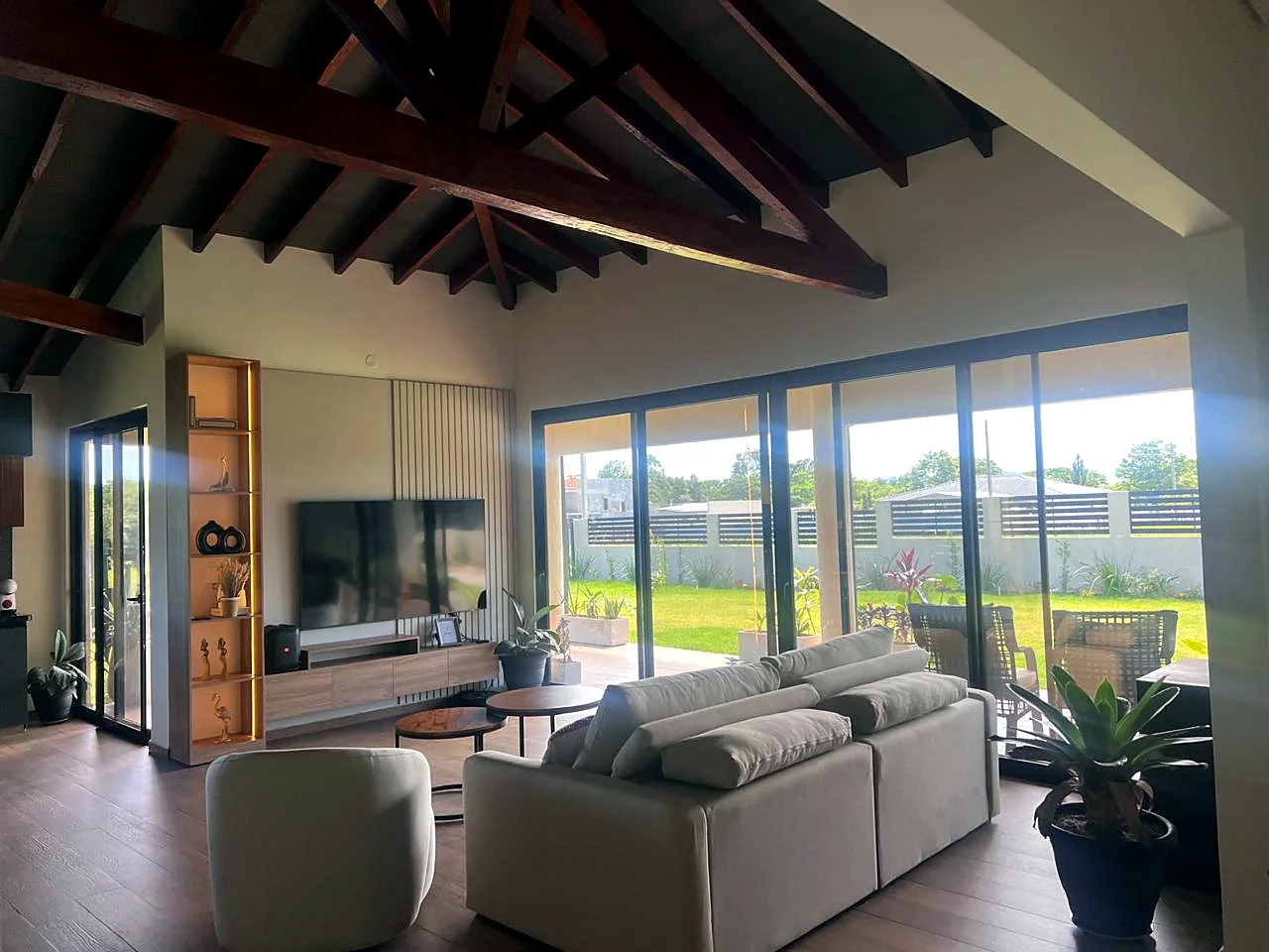 Salón de la casa con techo de madera y ventanales